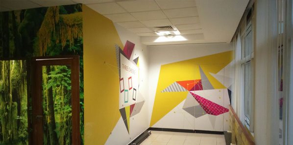 Origami-geometric colour graphics on a white EdgeVerve corridor wall.