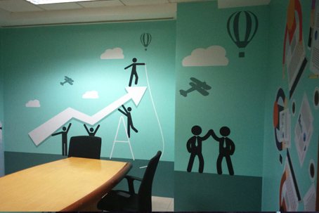 Aspirational pictogram graphics in an EdgeVerve meeting room — figures scaling a rising growth arrow with hot-air balloons.